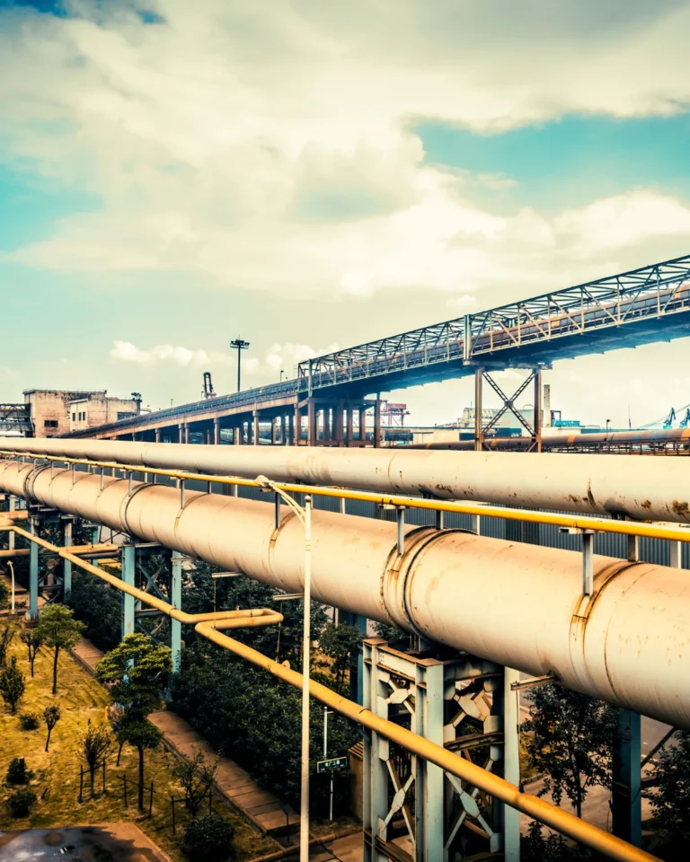 Industrial pipelines and metal structures under cloudy sky